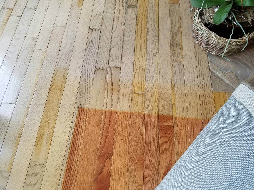 An image showing the immense color difference between hardwood flooring exposed to UV and the portion that had been covered by an area rug, which can be refinished and corrected by ReCoat Revolution.