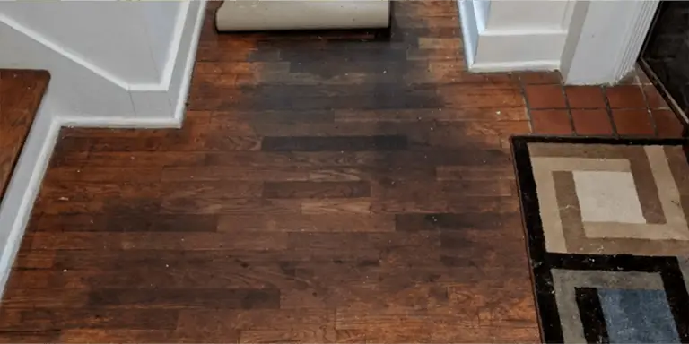 A hardwood floor with dark staining and spots where the dirt and grime was trapped by Murphy's Oil Soap, requiring a deeper clean to remove and refinish by ReCoat Revolution.