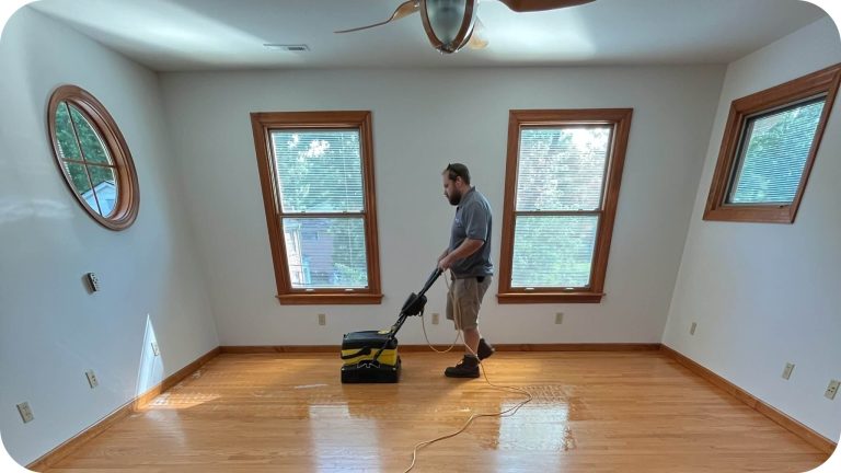 A ReCoat Revolution technician removing acrylic wax and contaminants from a residential hardwood floor to prepare for refinishing.